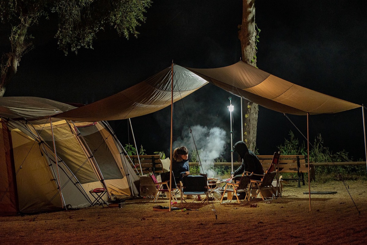 Cocina de campamento con estufa portátil y sartén de hierro.