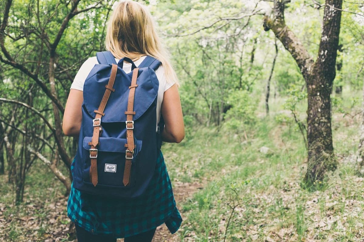 Itens essenciais de mochila pequenos espalhados no chão