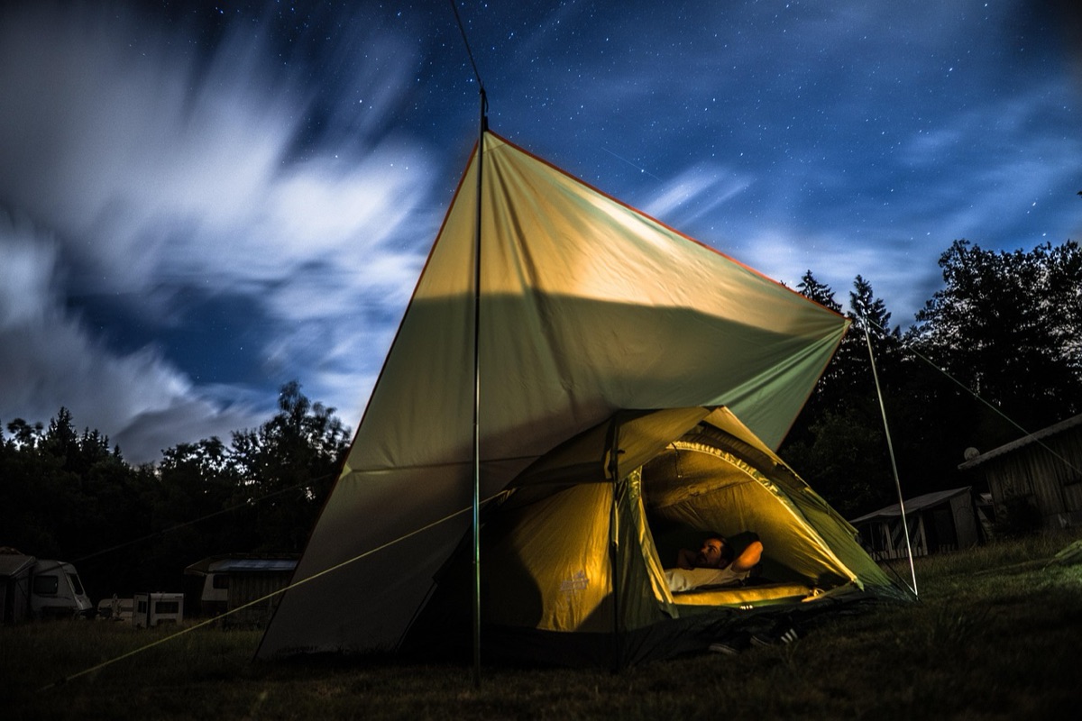 Installation d'une tente dôme sur un terrain plat en camping.